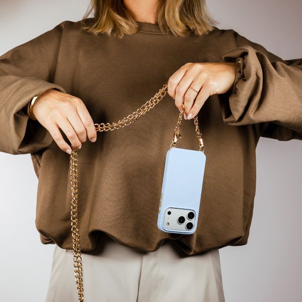 Selencia Rivièra MagSafe Backcover met afneembare haakjes voor de Apple iPhone 17 Pro - Powder Blue + Bold Chain (130 cm) - Gold